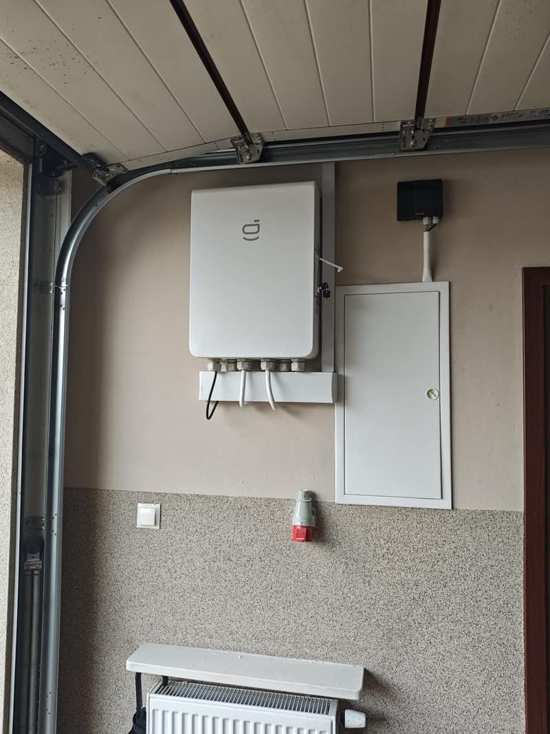 Rozdzielnica systemu magazynowania energii zamontowana przy bramie garażowej
