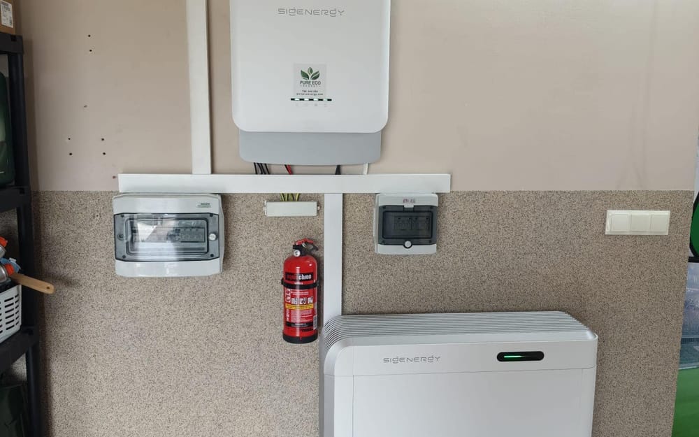 Falownik hybrydowy Sigenergy z magazynem energii SigenStor 24 kWh w garażu — obok gaśnica